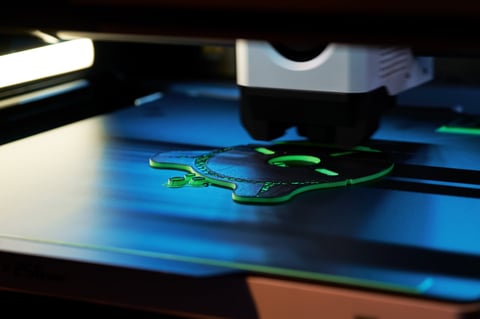3D printer layering green filament to form object
