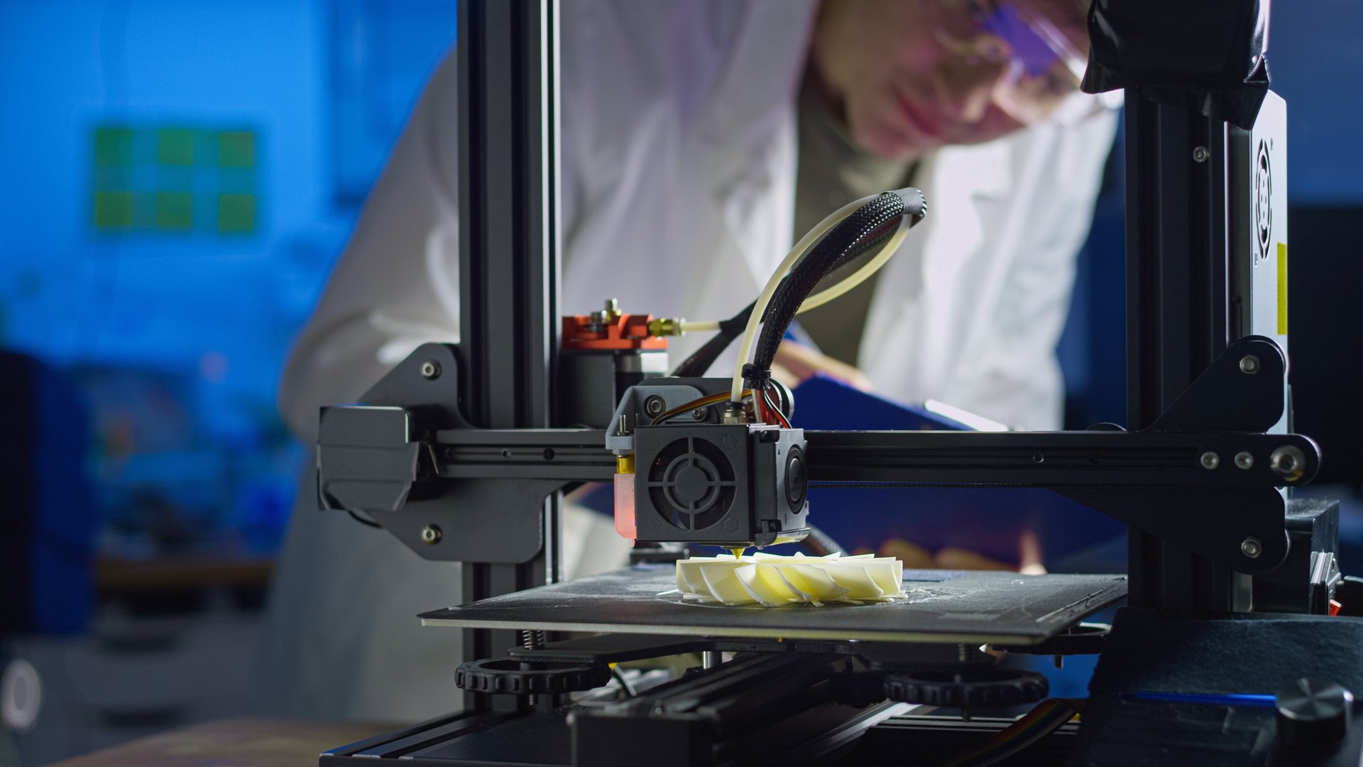 Engineer adjusting 3D printer in modern lab